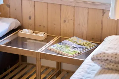 a table in a room with a bed and magazines at BL1304-Blokhus-Bag-Hojen-45 in Blokhus