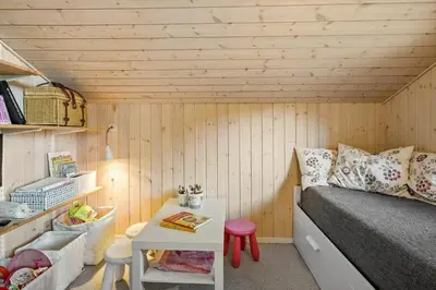 a small room with a bed and a table at BL1304-Blokhus-Bag-Hojen-45 in Blokhus