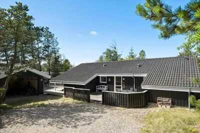 a house with a fence in front of it at BL1304-Blokhus-Bag-Hojen-45 in Blokhus