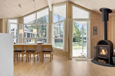 a dining room with a table and a fireplace at BL1304-Blokhus-Bag-Hojen-45 in Blokhus