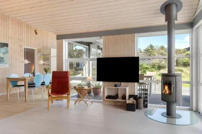 a living room with a fireplace and a tv at BL935-Blokhus-Tobaksvej-1 in Blokhus