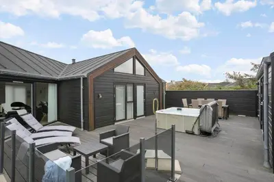a deck with chairs and a hot tub on a house at BL234-Blokhus-Sdr-Strandvej-9-A in Blokhus