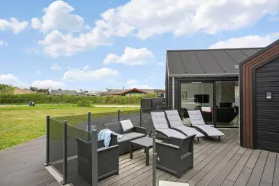 a patio with chairs and tables on a deck at BL234-Blokhus-Sdr-Strandvej-9-A in Blokhus