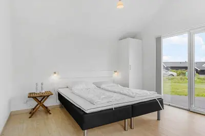 a white bedroom with a bed and a window at BL234-Blokhus-Sdr-Strandvej-9-A in Blokhus
