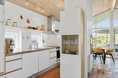 a kitchen with white cabinets and a dining room at BL1773-Saltum-Egernvej-6 in Saltum