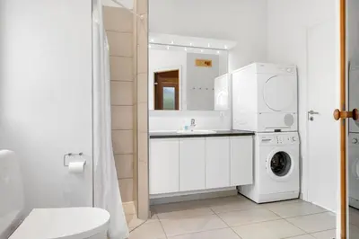 a bathroom with a sink and a washing machine at BL1660-Saltum-Hvide-Klit-7 in Saltum