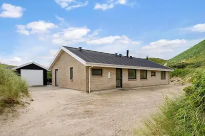 a house with a garage in the middle of a field at BL1660-Saltum-Hvide-Klit-7 in Saltum