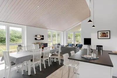 a dining room and living room with a table and chairs at BL1660-Saltum-Hvide-Klit-7 in Saltum