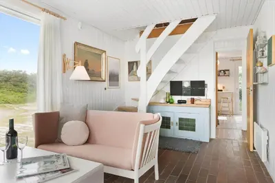 a living room with a pink couch and a table at BL1580-Saltum-Kohlsvej-17 in Saltum