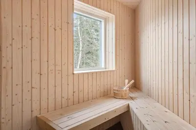 a sauna with a window and a wooden bench at BL1367-Blokhus-Saetergaardsstien-12 in Blokhus
