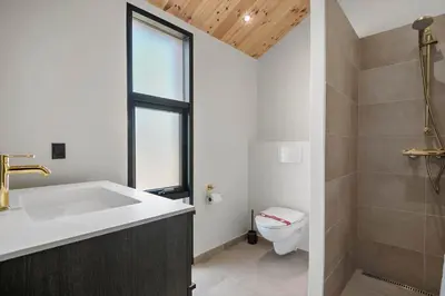 a bathroom with a sink and a toilet and a window at BL1436-Blokhus-Mollevej-13 in Blokhus