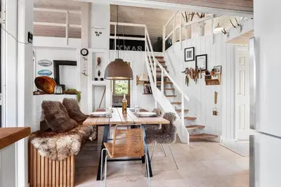 a dining room with a table and chairs and a staircase at BL1211-Blokhus-Carl-Nielsensvej-3 in Blokhus