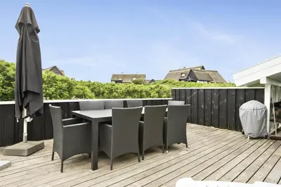a patio with a table and chairs on a deck at BL738-Saltum-Graabakken-53 in Saltum
