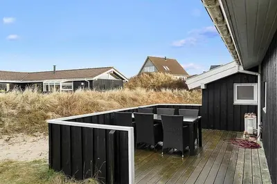 a deck with a table and chairs on a house at BL738-Saltum-Graabakken-53 in Saltum