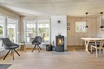 a living room with a fireplace and a table and chairs at BL1361-Saltum-Jaerens-Rev-Sydvest-8 in Saltum