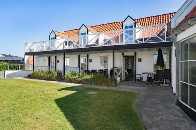a house with a balcony and a patio at BL1584-Blokhus-Strandvejen-14-Lejl-4 in Blokhus