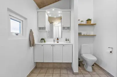 a white bathroom with a toilet and a sink at BL1790-Blokhus-Jens-Baerentsvej-28 in Blokhus