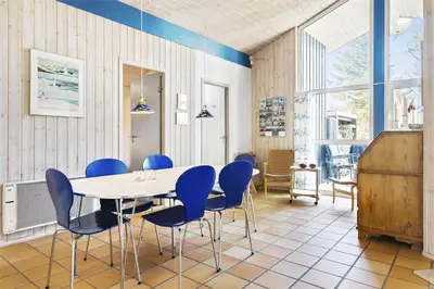 a dining room with a table and blue chairs at BL1720-Saltum-Kvansletten-27 in Saltum