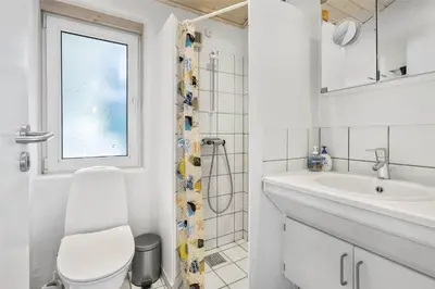 a white bathroom with a toilet and a sink at BL1720-Saltum-Kvansletten-27 in Saltum