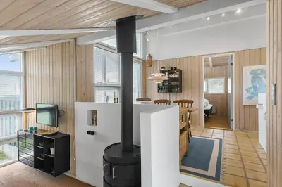 a kitchen and living room with a wood burning stove at BL343-Saltum-Raabukvej-24 in Saltum
