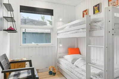 a bedroom with two bunk beds and a window at BL1487-Saltum-Brune-Banke-7 in Saltum