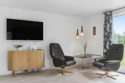 a living room with two chairs and a tv at BL1487-Saltum-Brune-Banke-7 in Saltum