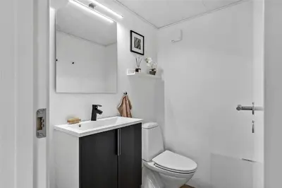 a bathroom with a sink and a toilet and a mirror at BL1632-Blokhus-Klintevej-14 in Blokhus