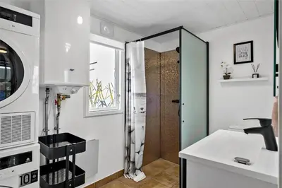 a small bathroom with a shower and a sink at BL1632-Blokhus-Klintevej-14 in Blokhus