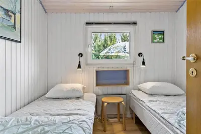 two beds in a room with a window and a tv at BL317-Saltum-Kalundborgvej-1 in Saltum
