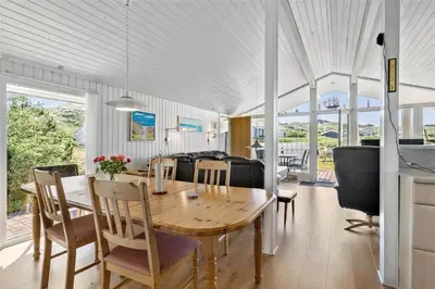 a dining room and living room with a table and chairs at BL317-Saltum-Kalundborgvej-1 in Saltum