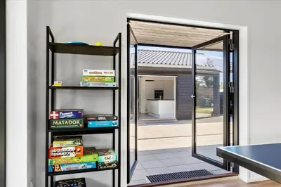 a room with a door open to a patio at BL1651-Blokhus-Pirupshvarrevej-21 in Blokhus