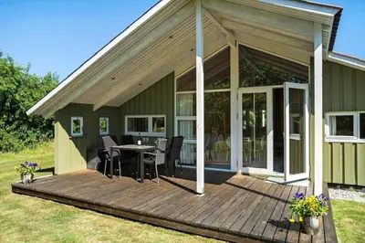 a house with a deck with a table and chairs at BL1374-Saltum-Sydvestpassagen-8 in Saltum