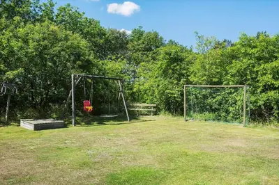 a park with two swings and a bench and trees at BL1374-Saltum-Sydvestpassagen-8 in Saltum