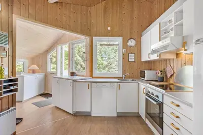 a kitchen with white appliances and wooden walls at BL1374-Saltum-Sydvestpassagen-8 in Saltum