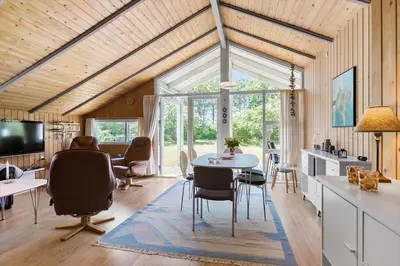a living room with a table and chairs and a tv at BL1374-Saltum-Sydvestpassagen-8 in Saltum
