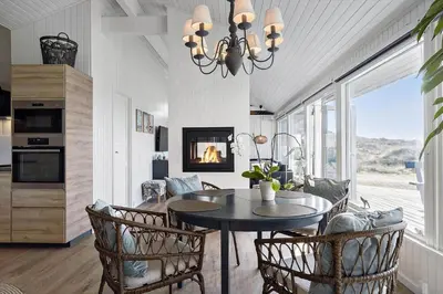 a dining room with a table and chairs and a fireplace at BL1530-Saltum-Kohlsvej-7 in Saltum