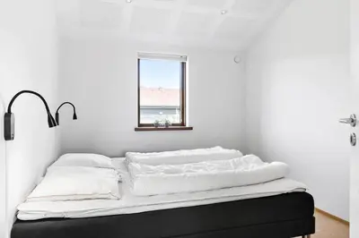 a bed with white sheets and a window in a room at BL1491-Saltum-Laustvej-10 in Saltum