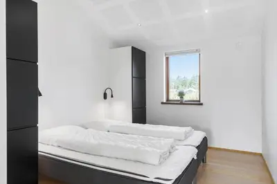 a white room with a bed with a window at BL1491-Saltum-Laustvej-10 in Saltum
