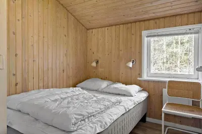 a bedroom with a bed in a wooden wall at BL286-Blokhus-Bag-Hojen-31 in Blokhus