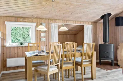 a dining room with a table and a stove at BL286-Blokhus-Bag-Hojen-31 in Blokhus