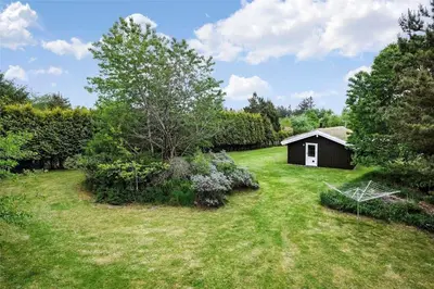 a garden with a small shed in the middle of it at BL286-Blokhus-Bag-Hojen-31 in Blokhus