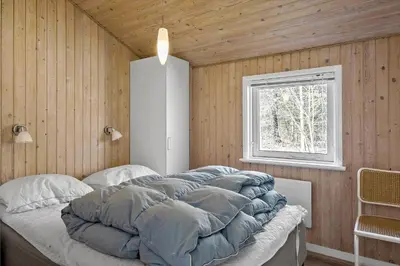 a large bed in a room with a window at BL286-Blokhus-Bag-Hojen-31 in Blokhus