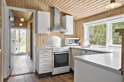 a kitchen with white cabinets and a stove top oven at BL286-Blokhus-Bag-Hojen-31 in Blokhus