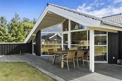 a patio with a table and chairs on a deck at BL1139-Blokhus-Sletten-3 in Blokhus