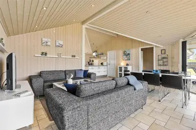 a living room with a couch and a table and a kitchen at BL1139-Blokhus-Sletten-3 in Blokhus