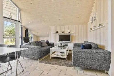a living room with two couches and a tv at BL1139-Blokhus-Sletten-3 in Blokhus