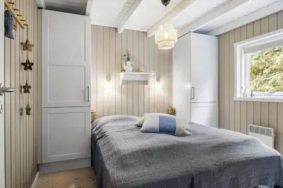 a bedroom with a bed and a window at BL1247-Blokhus-Skraavejen-24 in Blokhus