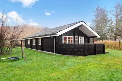 a black house with a gambrel roof at BL1788-Blokhus-Gyvelvej-21 in Blokhus