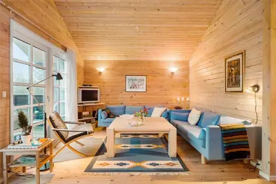 a living room with a blue couch and a table at BL1788-Blokhus-Gyvelvej-21 in Blokhus