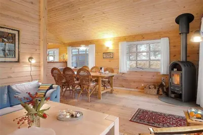 a living room with a table and a wood stove at BL1788-Blokhus-Gyvelvej-21 in Blokhus